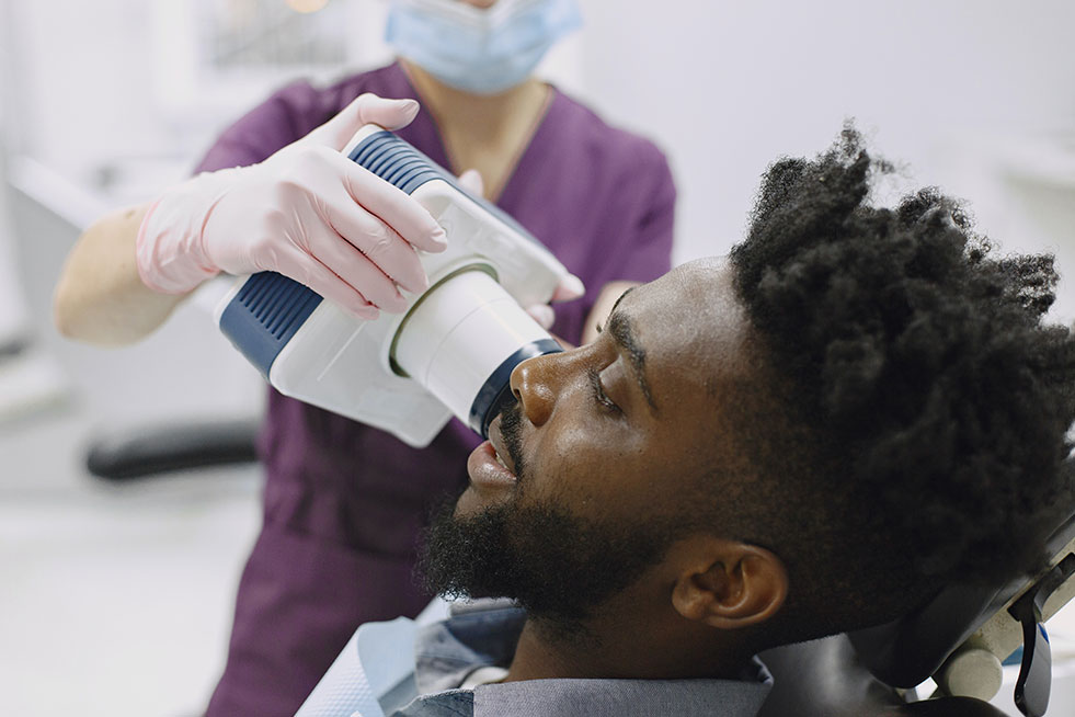 an assistant doing the x-ray of the patient's teeth